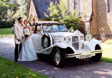Невеста с женихом и белый свадебный автомобиль