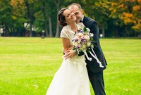 Жених обнимает невесту с букетом